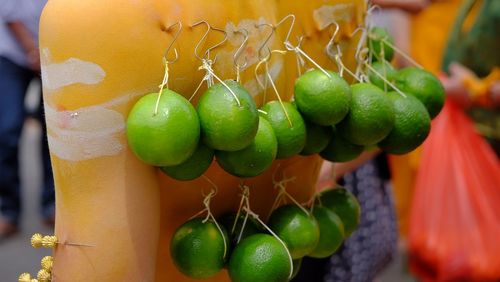 Close-up of limes hanging for sale at market stall