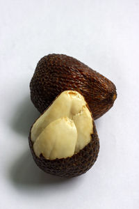 Close-up of snake fruit against white background