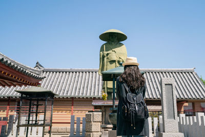 Low angle view of statue against building against clear sky