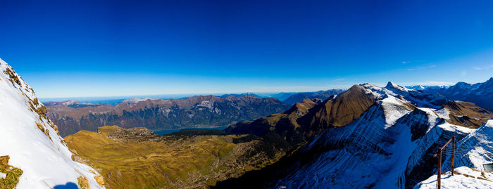 Scenic view of snowcapped mountains against blue sky