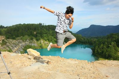 Full length of young man jumping on mountain