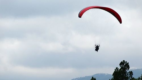 Low angle view of paragliding against sky