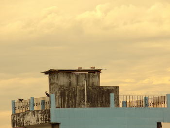 Buildings against cloudy sky at sunset