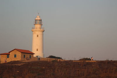 Lighthouse amidst buildings against sky