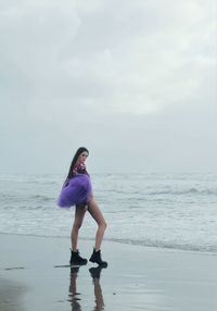 Full length of woman standing at beach