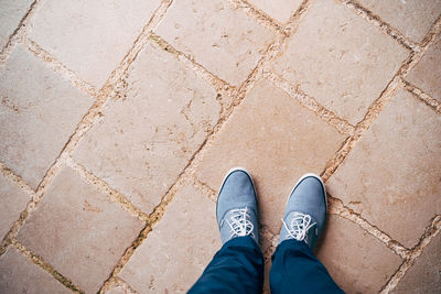 Low section of person standing on footpath