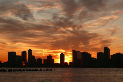 Silhouette buildings against sky during sunset