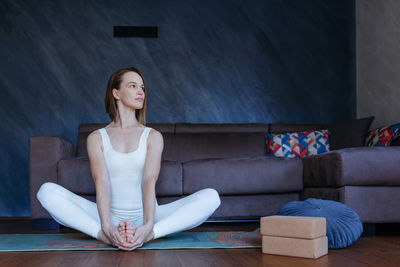 Young woman sitting on sofa at home