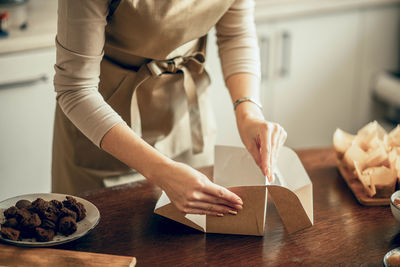 Woman bakery shop owner holding delivery box for customer order. food delivery concept.