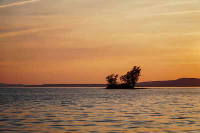 Scenic view of lake against romantic sky at sunset