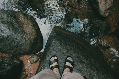 Low section of man standing on rock