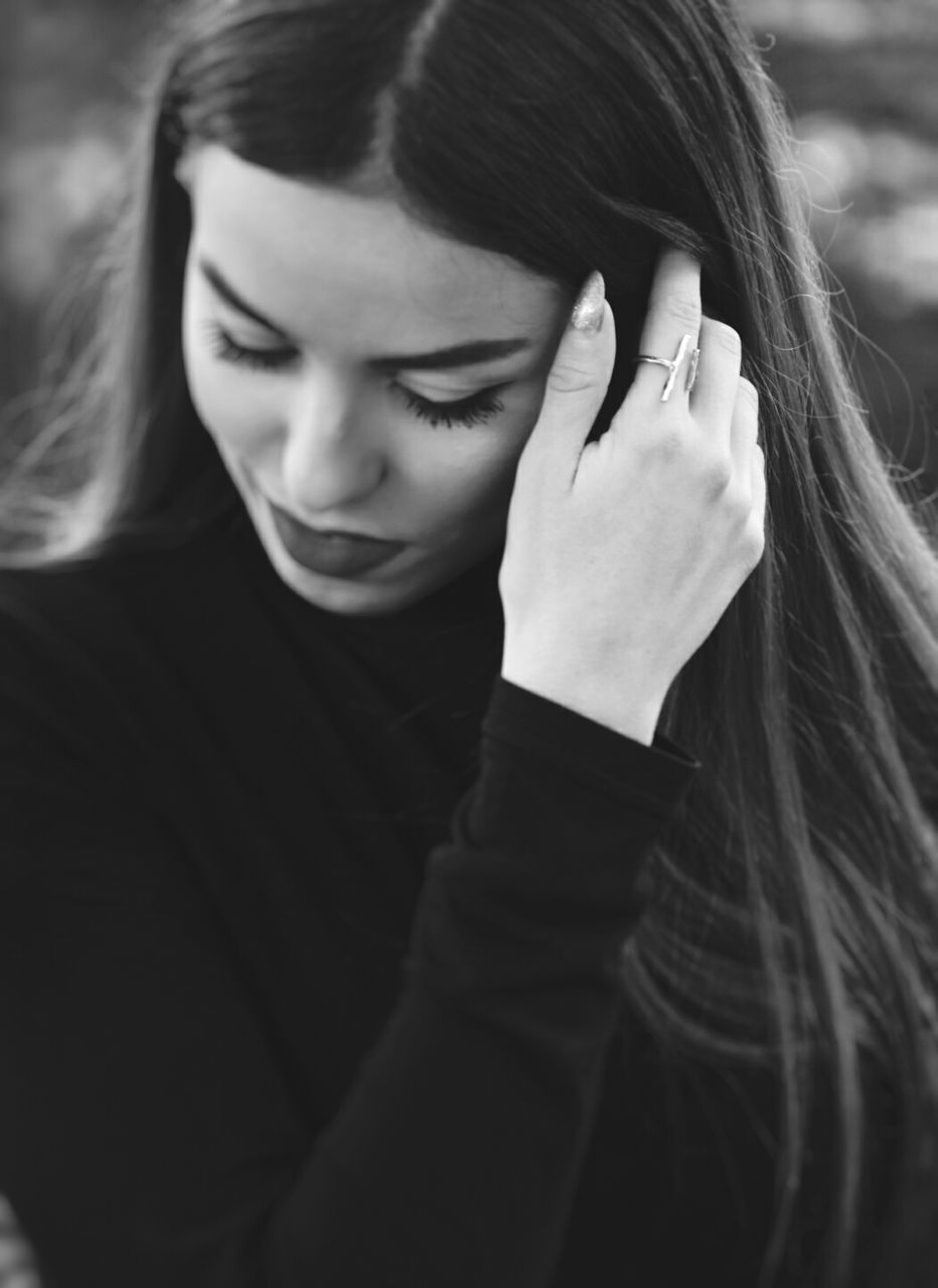 one person, looking down, real people, childhood, young adult, tensed, lifestyles, young women, close-up, outdoors, human hand, day