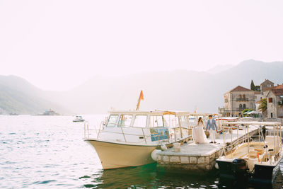 Boats moored in sea against clear sky