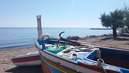 Ship moored on beach against clear sky