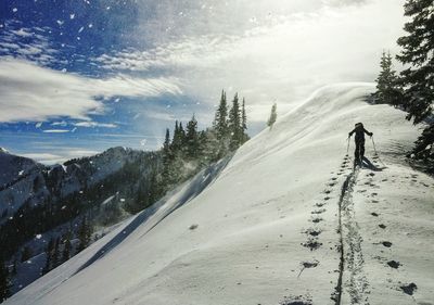 Silhouette person skiing on snowcapped mountain