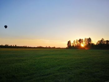 Scenic view of field against clear sky during sunset