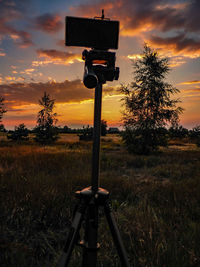 Cross on field against sky during sunset