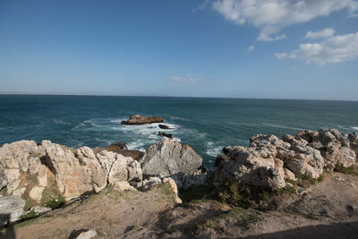 Scenic view of rocks in sea against sky