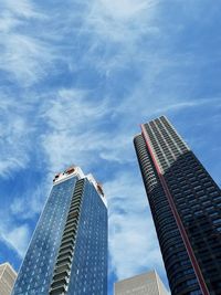 Low angle view of modern buildings against blue sky