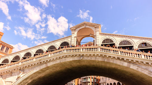 Low angle view of arch bridge against cloudy sky