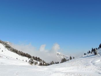 Scenic view of snowcapped mountains against clear blue sky