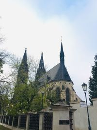 Low angle view of trees and building against sky