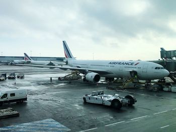 Airplane on airport runway against sky