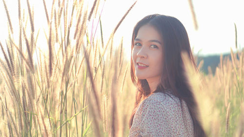 Portrait of young woman standing on field