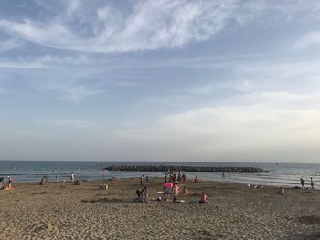 People at beach against sky