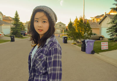 Portrait of beautiful young woman standing against built structure