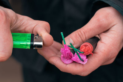 Close-up of hand holding pink flowers