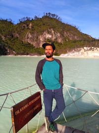 Portrait of young man standing against sea