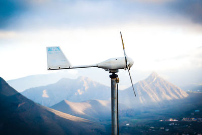 Communications tower against mountain range against sky