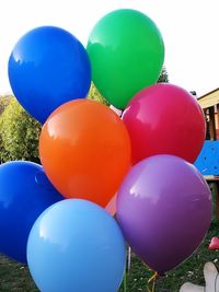 Close-up of multi colored balloons against blue sky