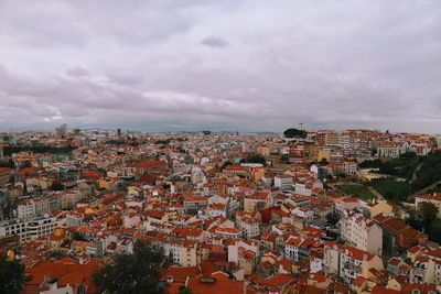 Aerial view of cityscape against cloudy sky