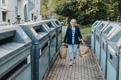 Woman carrying paper bags with recycling