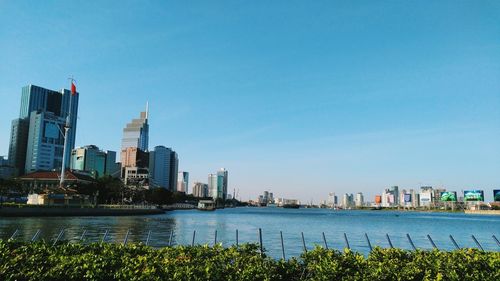 River with buildings against clear blue sky