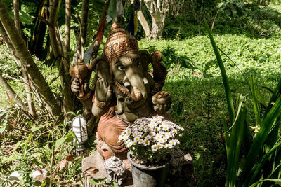 Statue amidst flowering plants