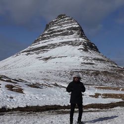 Full length of woman standing on snowcapped mountain