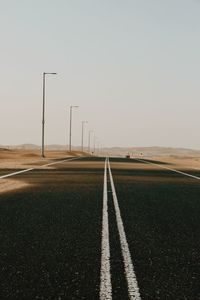 Empty road on field against clear sky