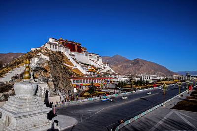 Low angle view of potala palace against clear blue sky on sunny day