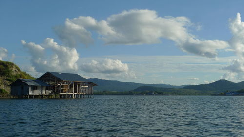 Houses by sea against sky