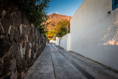 Road amidst buildings against sky