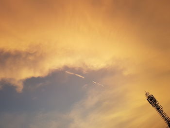 Low angle view of silhouette airplane against sky during sunset