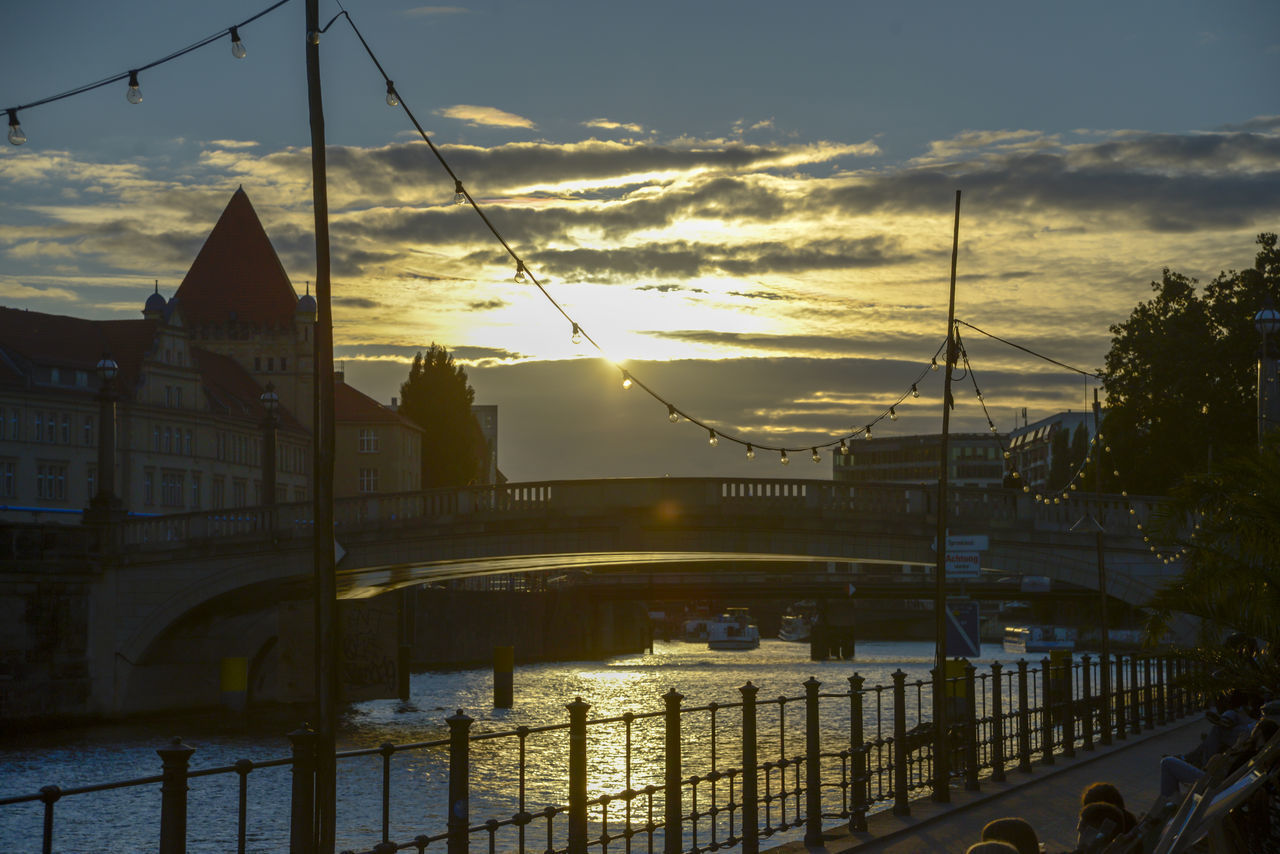 SILHOUETTE BRIDGE OVER CANAL AGAINST SKY AT SUNSET