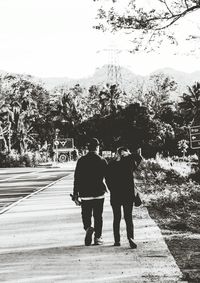 Rear view of couple walking on road