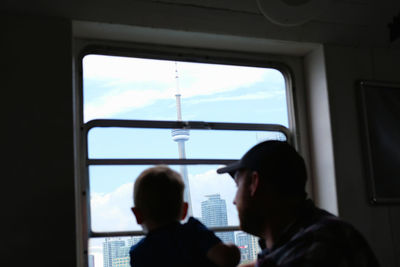 Rear view of man and woman seen through window