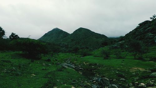 Scenic view of mountains against cloudy sky