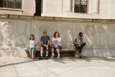 Full length portrait of two children on building in city