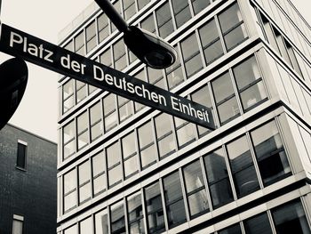 Low angle view of road sign against building